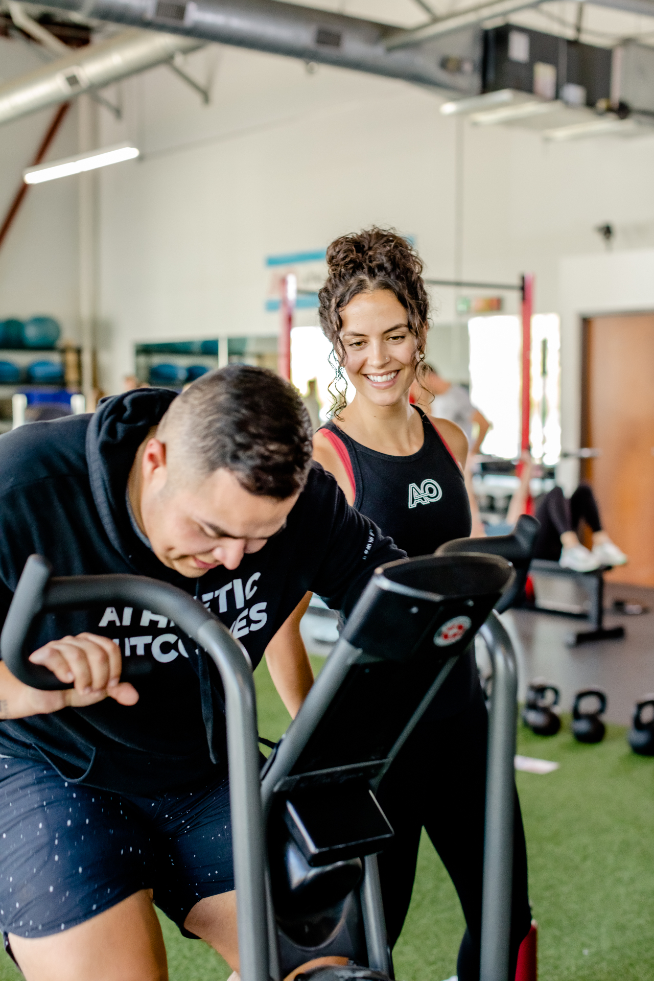 Coach guiding an athlete through a training session at Athletic Outcomes